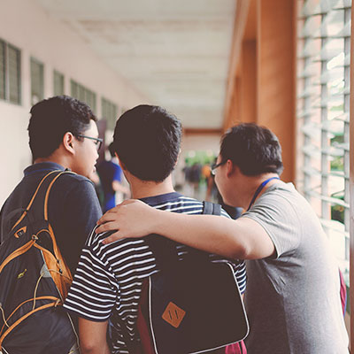 Friends with backpacks on at school.